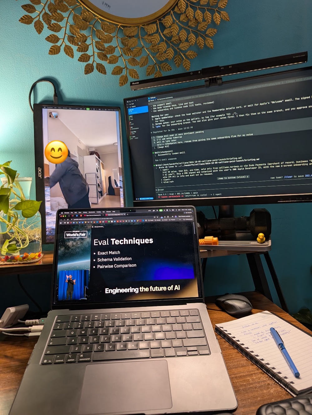 A MacBook playing a YouTube talk while a FaceTime call runs on the monitor next to it.